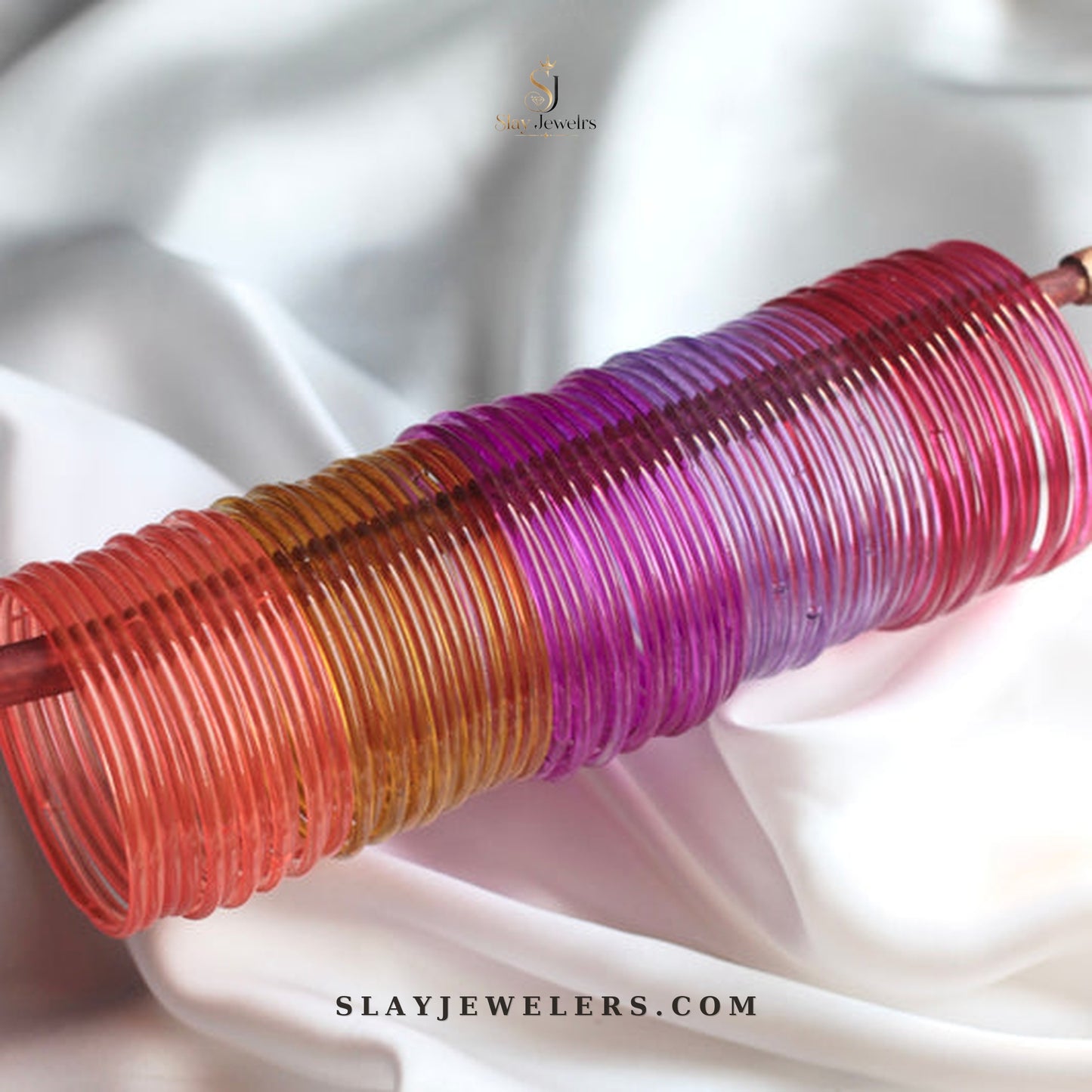 Warm sunset jelly bangles in coral, gold, purple, magenta, and pink — Slay Jewelers